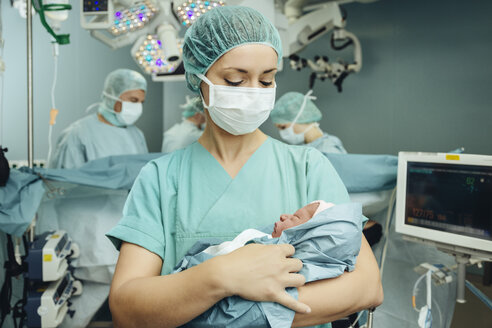 OP-Schwester hält Neugeborenes im Operationssaal - MFF002366