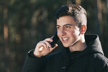 Porträt eines Teenagers, der mit seinem Mobiltelefon spricht - BZF000266