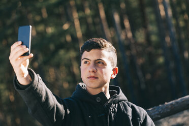 Porträt eines Teenagers, der ein Selfie mit seinem Mobiltelefon macht - BZF000268