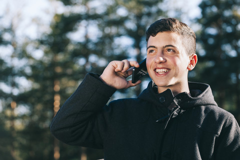 Porträt eines Teenagers, der mit seinem Mobiltelefon spricht, lizenzfreies Stockfoto