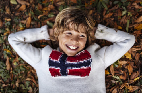 Porträt eines lächelnden blonden Jungen, der einen Pullover mit norwegischer Flagge trägt - MGOF000874