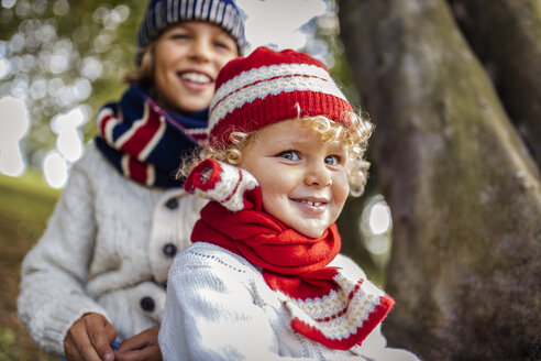 Porträt eines blonden kleinen Jungen und seines Bruders im Hintergrund, der modische Strickkleidung im Herbst trägt - MGOF000881