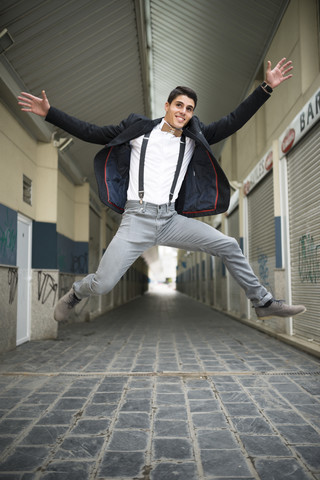 Eleganter Mann springt auf eine Gasse, lizenzfreies Stockfoto