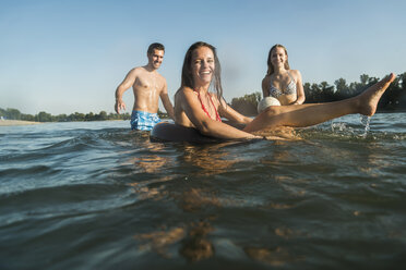 Glückliche Freunde mit Schlauch und Ball im Wasser - UUF005886