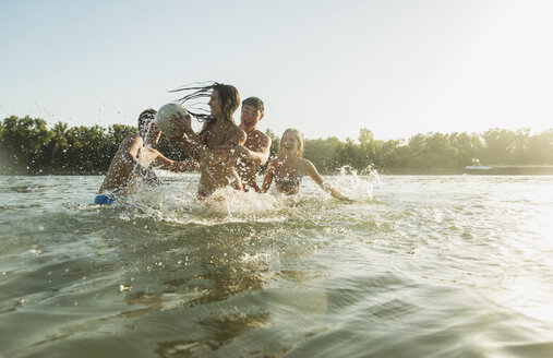 Glückliche Freunde mit Ball im Wasser - UUF005895