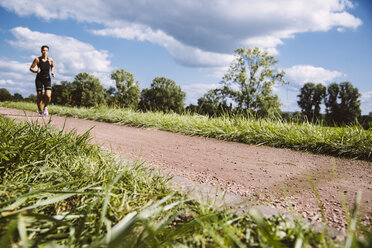 Female triathlete running on dirt track - MFF002382