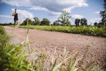 Female triathlete running on dirt track - MFF002383