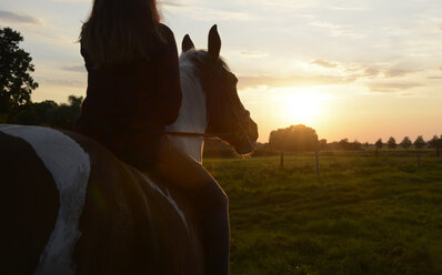 Junge Frau reitet in den Sonnenuntergang - BFRF001559