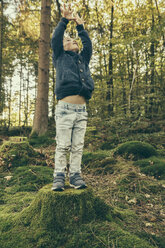 Little boy standing on tree stump reaching up - MFF002415