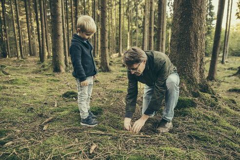 Älterer Mann sammelt Steinpilze mit kleinem Jungen - MFF002431