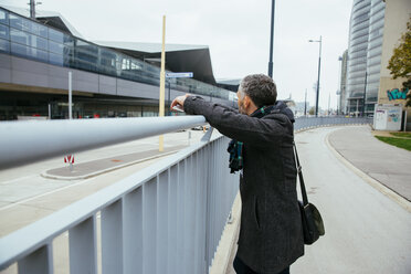 Österreich, Wien, Mann lehnt an einem Geländer und schaut auf den Hauptbahnhof - AIF000108