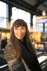 Deutschland, Berlin, lächelnde junge Frau wartet am Bahnsteig - FKF001407