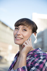 Germany, Berlin, portrait of young woman telephoning with smartphone - FKF001420