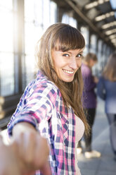 Portrait of smiling young woman holding hands - FKF001427