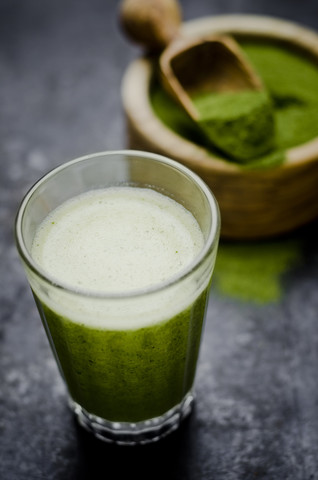 Moringa-Smoothie mit Orangen- und Zitronensaft, Moringa-Pulver in Holzschale, lizenzfreies Stockfoto