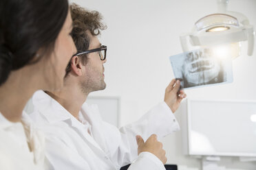 Zwei Zahnärzte in einer Zahnarztpraxis besprechen ein Röntgenbild - FKF001505