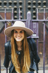 Spanien, Barcelona, lächelnde junge Frau vor einem Eingangsportal - EBSF000936