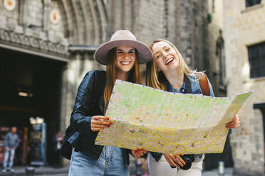 Spain, Barcelona, two happy young women reading map - EBS000942