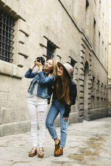 Spanien, Barcelona, zwei junge Frauen, die in der Stadt spazieren gehen und Fotos machen - EBSF000948