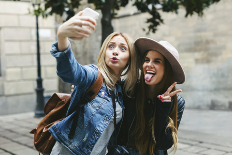 Two playful young women taking a selfie stock photo