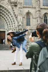 Spain, Barcelona, woman taking picture of two playful young women in the city in the city - EBSF000954