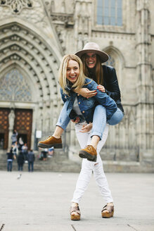Spanien, Barcelona, glückliche junge Frau, die ihren Freund huckepack trägt, in der Stadt - EBSF000955