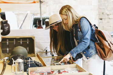 Zwei junge Frauen an einem Stand auf einem Flohmarkt - EBSF000961