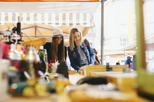 Zwei junge Frauen an einem Stand auf einem Flohmarkt - EBSF000962