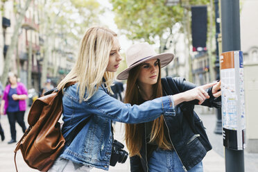 Spanien, Barcelona, zwei junge Frauen betrachten einen Stadtplan auf einer Stange - EBSF000966