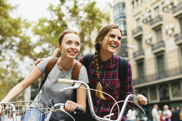 Spain, Barcelona, two young women on bicycles in the city - EBSF000972