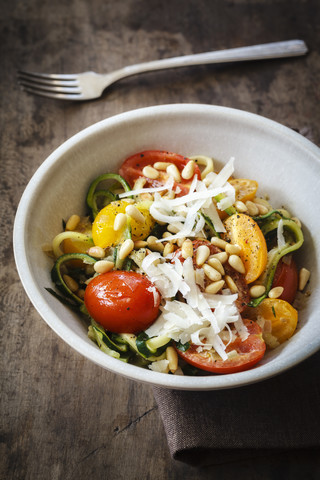 Helixartig gewickelte Zucchini, Gemüsenudeln, Tomate und Parmesan in Schale, lizenzfreies Stockfoto