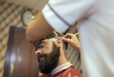 Barbier rasiert Bart eines Kunden - MGOF000889