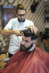 Friseur schneidet einem Kunden die Haare - MGOF000892