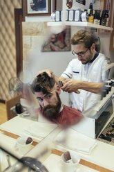 Friseur schneidet einem Kunden die Haare - MGOF000895