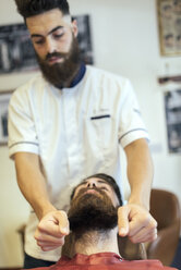 Friseur, der den Bart eines Kunden zurechtrückt - MGOF000905