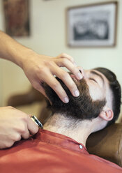 Barbier rasiert Bart eines Kunden - MGOF000906