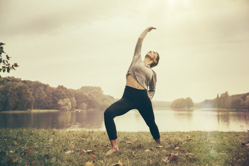 Frau macht eine umgekehrte Krieger-Yoga-Pose im Autmny Park - MFF002441