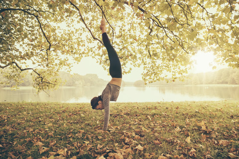 Frau in Tänzerstellung, Yoga-Pose, im Autmny Park, lizenzfreies Stockfoto