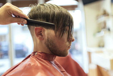 Friseur kämmt das Haar eines Kunden - MGOF000932