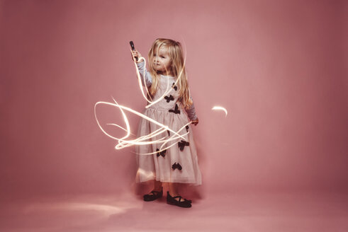 Kleines Mädchen Lightpainting mit einer Fackel vor einem rosa Hintergrund - IPF000255