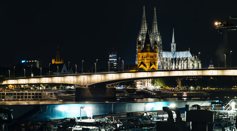 Deutschland, Köln, Blick auf den Kölner Dom mit Groß Sankt Martin und Deutzer Brücke bei Nacht, lizenzfreies Stockfoto