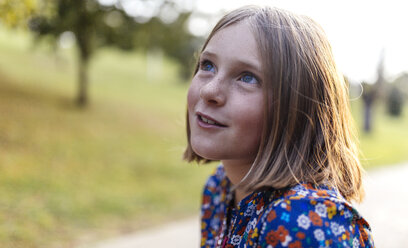 Portrait of smiling blond girl with freckles looking up - MGOF000942