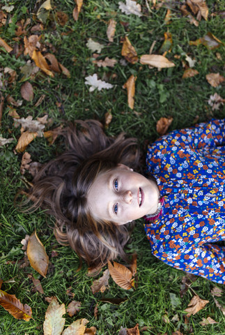 Porträt eines auf einer Wiese liegenden Mädchens, lizenzfreies Stockfoto