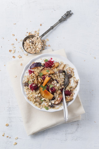 Schale mit Sauermilch, Quinoa, Früchtemüsli, Pflaumen und Himbeeren, lizenzfreies Stockfoto