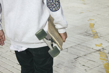 Young man carrying his longboard - ABZF000140