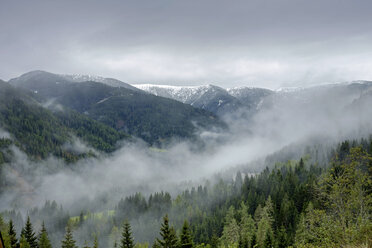 Österreich, Steiermark, Murau, schneebedeckte Berge und Nebel im Tal - HLF000934