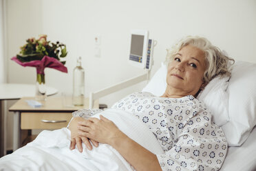 Ältere Frau im Krankenhaus im Bett liegend, mit besorgtem Blick - MFF002460