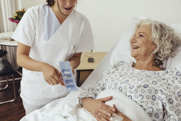 Nurse explaining medication to senior woman in hospital - MFF002474