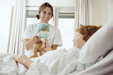 Junge im Krankenhausbett erhält Spielzeug von Krankenschwester - MFF002494