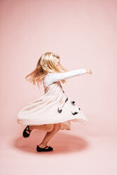 Kleines Mädchen tanzt vor einem rosa Hintergrund - IPF000263